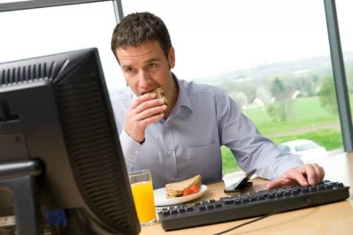 Office workers eat junk food as they work in front of the computer. jpg