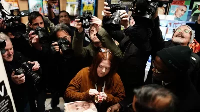 Reporters and photographers gathered round the first customers at WH Smith. Large retailers have already been selling the book at half price. Photo: BBC